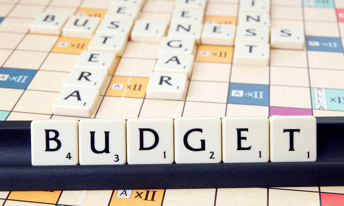 Ordet budget syns i förgrunden med en spelplan bakom. 